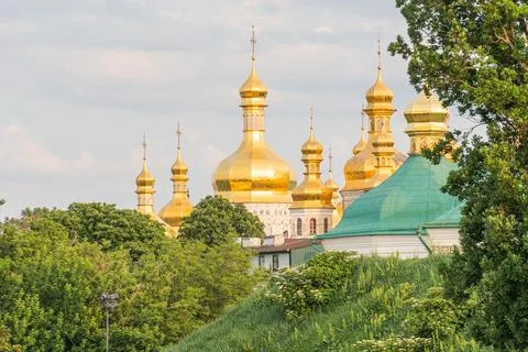 Large religious complex with multiple golden-domed buildings and a smaller .. Stock Photos