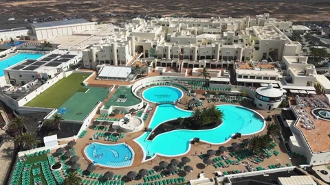 Large Resort with Interconnected Turquoise Pools and White Buildings Видео 344952783
