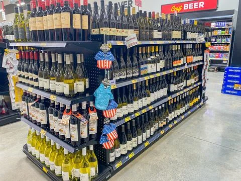 A large retail display shelf filled with various bottles of wine in a store.. Stock Photos