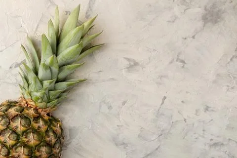 Large ripe fruit pineapple. Half a pineapple on a light concrete background. Foto stock