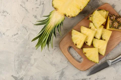 Large ripe fruit pineapple. Pineapple slices on a cutting board on a light co Foto stock