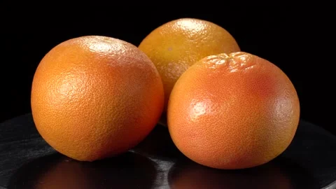 Large ripe grapefruits on a black background close-up. Stock Footage 147488879