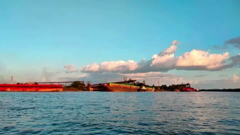 A large river with a coal cargo ship visible in the distance during the day. 4K Stock Footage 287687881