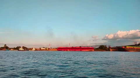 A large river with a coal cargo ship visible in the distance during the day. 4K Stock Footage 287687968