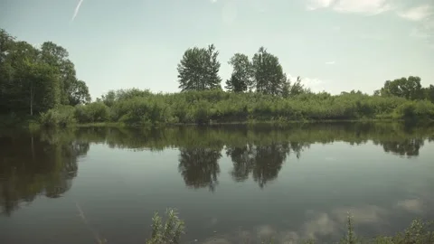 A large river flowing through remote nature with reflection in the water Stock Footage 159981086
