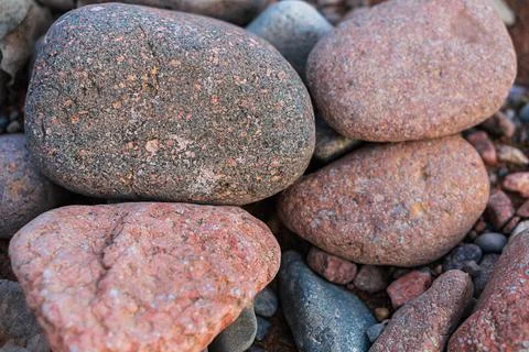 Large river red polished rounded stones pebbles with inclusions of white, b.. Stock Photos