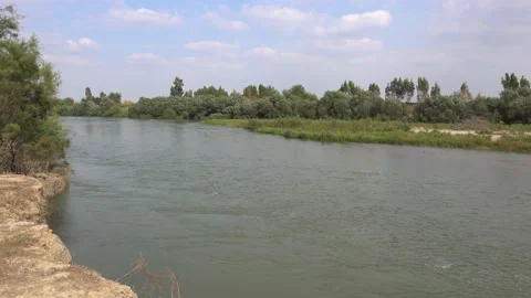 Large River Surrounded by Soil and Trees in Flat Plain Stock Footage 144037976