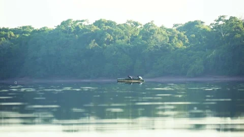 A Large River Water Surface With A Wooded Bank And A Boat With Two Fishermen Stock Footage 167823863