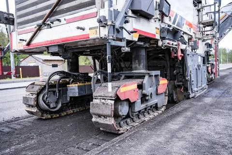 Large Road cold milling machine removes the old asphalt and loading Foto stock