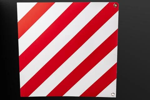 A large road sign displays a pattern of red and white stripes, warning driver Stock Photos