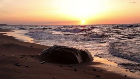 A large rock on the beach at sunset Stock Footage 72659887