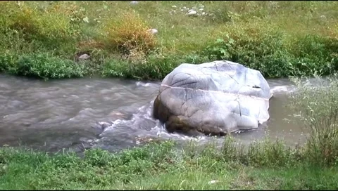 Large rock boulder in middle of flowing river stream Stock Footage 346540233
