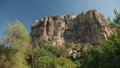 A large rock formation surrounded by green trees Stock Footage 280838298