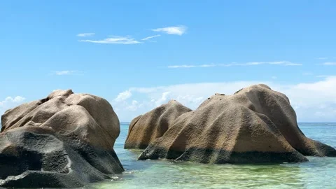 Large rocks by the clear water at a beach in Seychelles Stock Footage 345729137