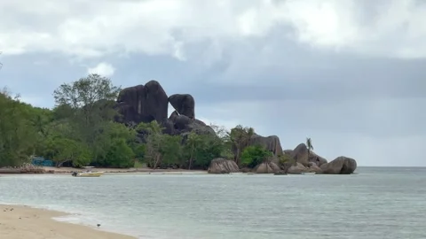 Large rocks by the clear water at a beach in Seychelles Stock Footage 345729139