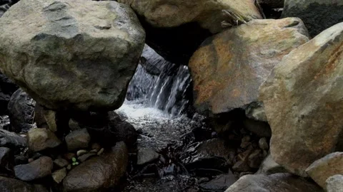 Large rocks crossed by a small, clear river Stock Footage 280379032
