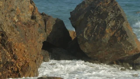 Large rocks by ocean. Waves crashing into rocky beach cu B Stock Footage 102402138