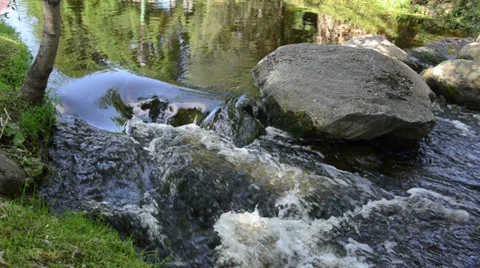 Large rocks swift flowing stream water jet strikes the stone Stock Footage 34255306