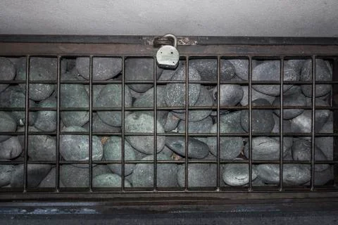 Large rocks under locked grate Stock Photos