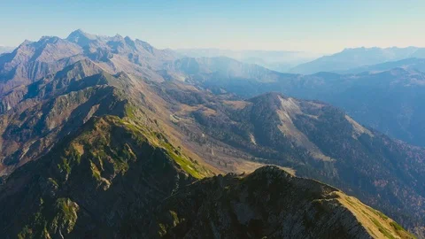 Large rocky mountain range with peaks and troughs, aerial view clear sunny day Video stock 119321975