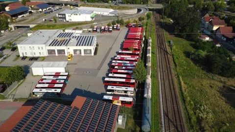 Large rooftop solar array by a railway line with a bus depot and freight train Stock Footage 341466204