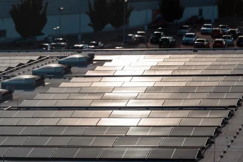 Large Rooftop Solar Panel Array with Urban Background and Reflections Stock Photos