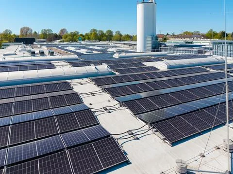 Large rooftop solar power installation on an industrial building under clea.. Stock Photos