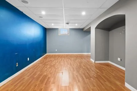 Large room with a blue wall and a wooden floor Stock Photos