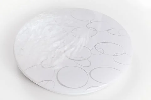 Large round ceiling lamp with a pattern on a white surface. Stock Photos