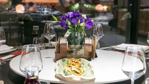 Large round dining table set for a group dinner with red wine Stock-Fotos