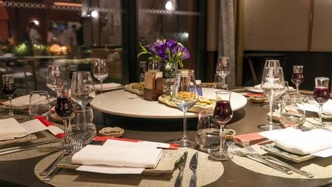 Large round dining table set for a group dinner with red wine Foto stock