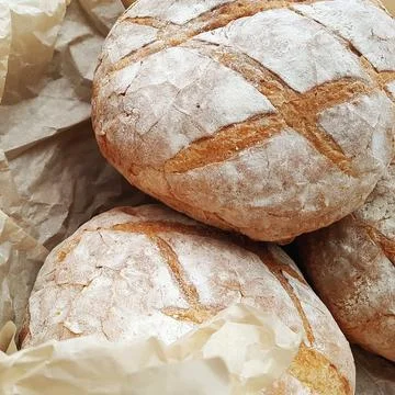 Large round loaves of rye bread lie on the counter of the store. Stock Photos