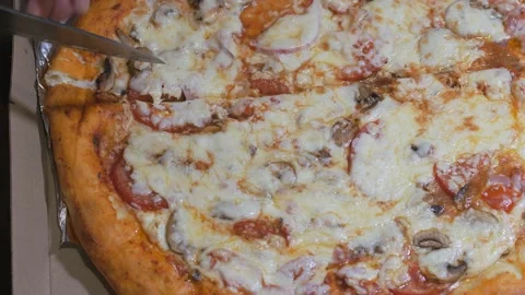 Large round pizza with a cheese side in a box. Cutting into pieces with a Video stock 150001164
