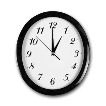 Large round white wall clock with black frame. The hands point to 1 o'clock.  Stock-Fotos