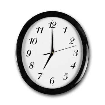 Large round white wall clock with black frame. The hands point to 7 o'clock.  Stock Photos