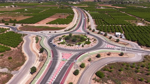 Large roundabout road junction surrounded by agricultural fields and orchards Stock Footage 341468748