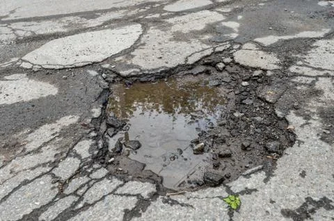 Large rounded pothole filled with water in Montreal Stock Photos