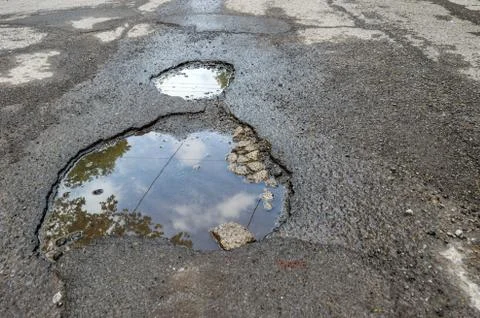 Large rounded pothole filled with water in Montreal Stock Photos