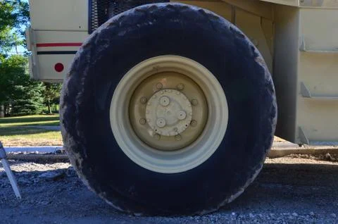 Large rubber Truck tire and wheel still attached to the construction equipment Stock Photos