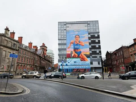 Large runner mural on building facade in Liverpool UK inspiring fitness and.. Stock Photos