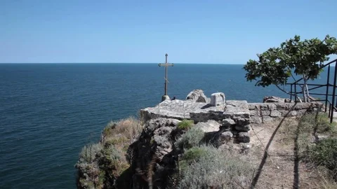 Large rusty iron cross and early Christian ruins at a seaside cape Stock Footage 70573164