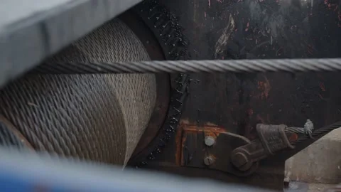 Large rusty machine gear turns slowly letting go an iron cable Stock Footage 209254812