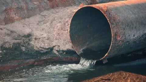A large rusty pipe from which polluted industrial water flows. Environmenta.. Stock Footage 245099604