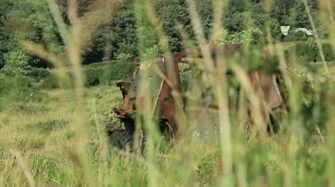 Large rusty vechicle behind long grass 5 Stock Footage 40718093