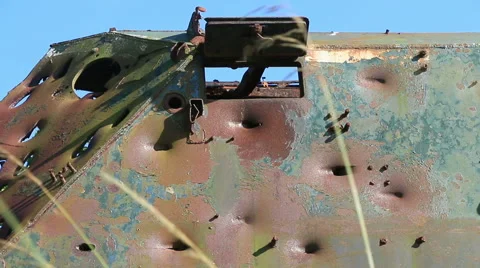 Large rusty vechicle behind long grass 8 bullet holes Stock Footage 40719972