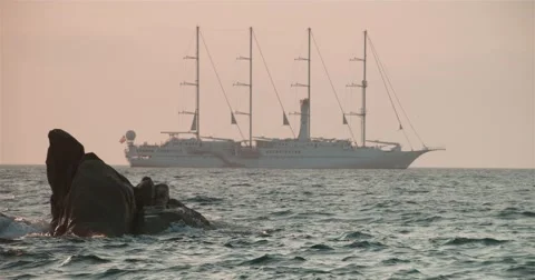 Large sailing ship moving along the rocky coast Stock Footage