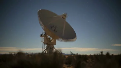 A large satellite dish points to the night sky full of stars 動画素材 312680376
