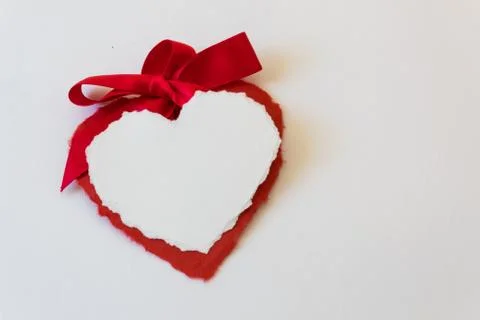 Large satin bow tops two paper heart valentines isolated on white, copy space Stock Photos