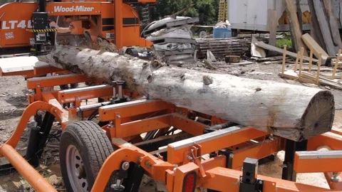 Large saw cutting machine chopping a wooden log in half. Stock Footage 102229338