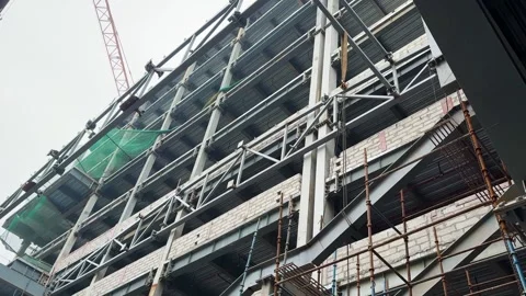 Large scale building construction progress with steel trusses and work platforms Stock Footage 329602632